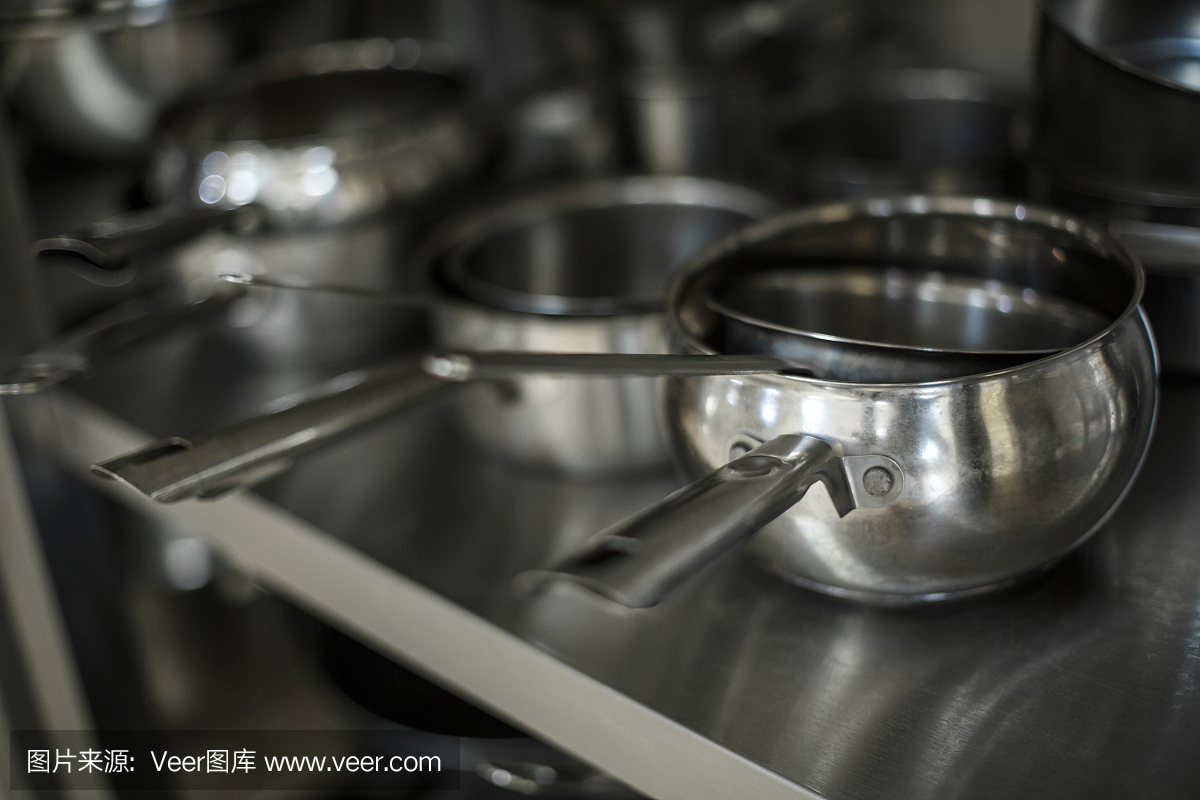 厨房里的一套黑色金属锅、锅和滤锅